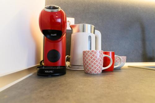 a red and white blender and cups on a counter at Tower Luxury Flats in Alexandroupoli