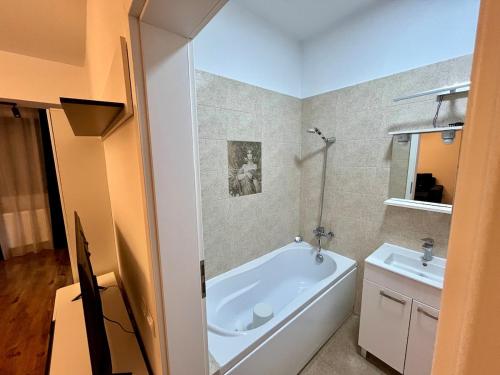 a bathroom with a bath tub and a sink at Ap nou cu 2 camere in centrul Bucureștiului in Bucharest