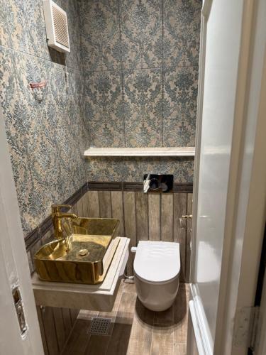 a bathroom with a gold sink and a toilet at Comfyheliopolis in Cairo