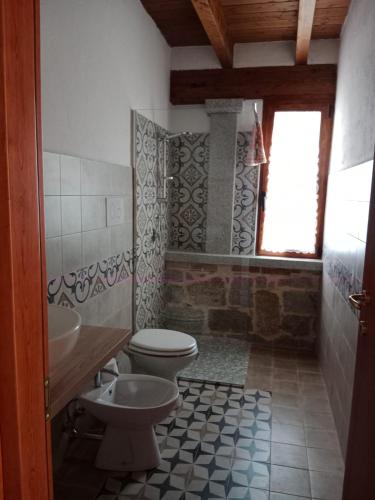 a bathroom with a toilet and a sink at Al mare a Capo Comino in Capo Comino