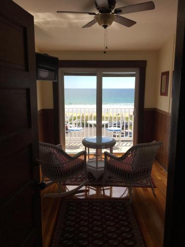 a room with a table and chairs and a view of the ocean at The Rebekah Inn in Old Orchard Beach