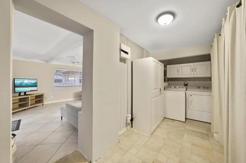 a kitchen with white appliances and a room with a tv at Home Wpool By Pmi Unit Dfs in Deerfield Beach