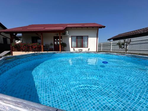 a large blue swimming pool in front of a house at Mountain View House Brasov in Braşov