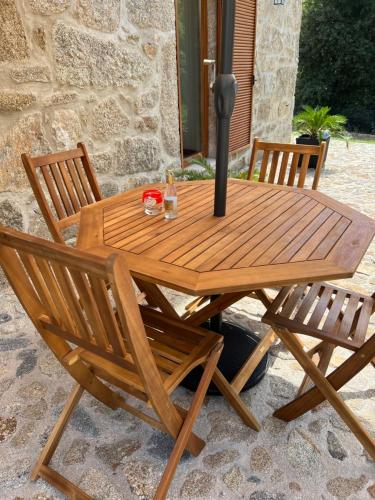 a wooden picnic table with two chairs and a lamp at Casa dos Manels in Arcos de Valdevez