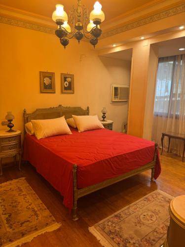 a bedroom with a red bed with two pillows at Comfyheliopolis in Cairo