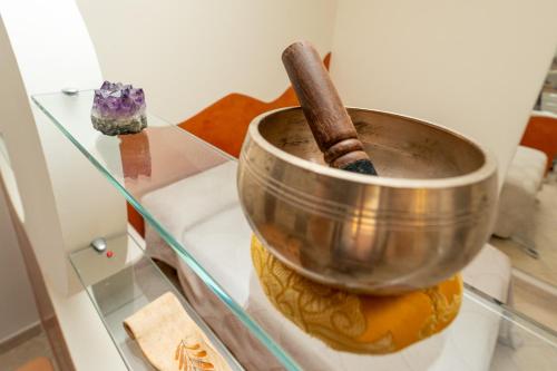 a metal bowl with a stick in it on a glass table at Turin Airport apt I in Leinì