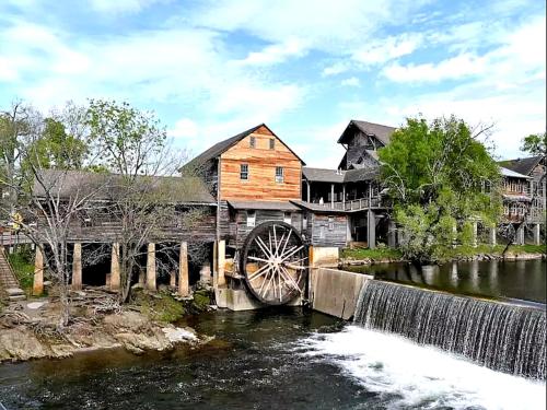 a wooden house with a water wheel on a bridge at All Time High in Cartertown