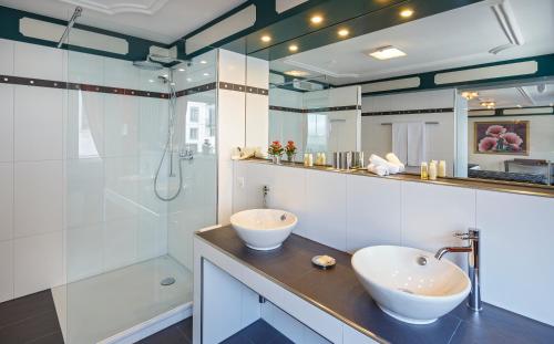 a bathroom with two sinks and a shower at Hotel Luzernerhof in Luzern