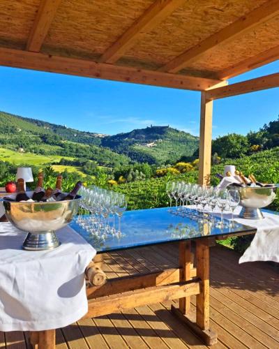 a table with wine glasses on a deck with a view at Re Artù Assisi Country Lifestyle in Assisi