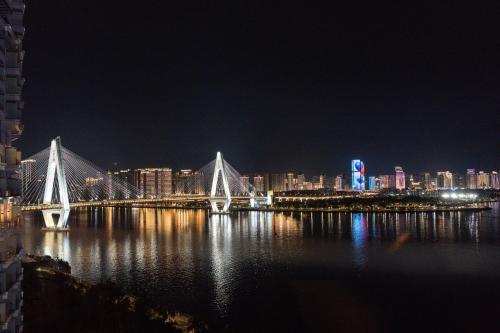 a bridge over a body of water at night at InterContinental Haikou Seaview by IHG in Haikou