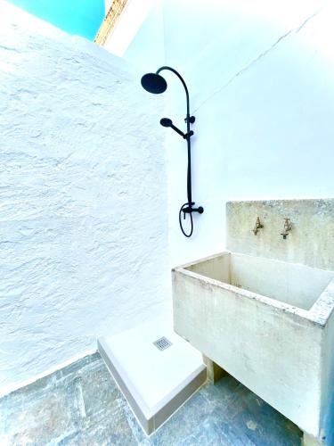 a bathroom with a sink and a light on the wall at Aquaterrae suite and water relax in Alezio