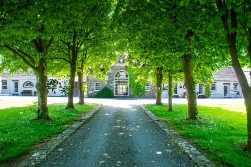 a tree lined driveway in front of a house at Coach House in Holyhead