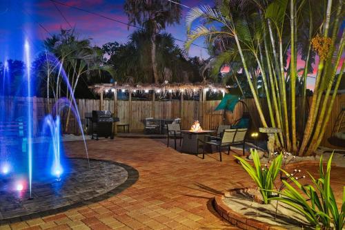 a fountain in the middle of a patio with palm trees at Coastal Villa W Amazing Courtyard - Splash Pad! in Sarasota