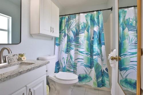 a bathroom with a toilet and a shower curtain at Coastal Villa W Amazing Courtyard - Splash Pad! in Sarasota