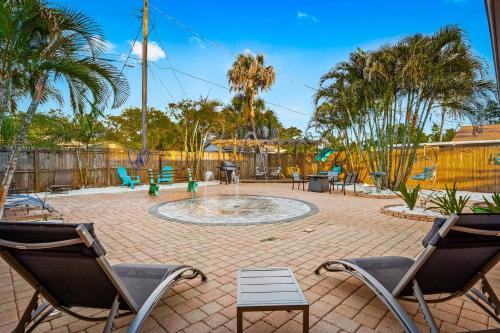 a patio with chairs and a fountain with a playground at Coastal Villa W Amazing Courtyard - Splash Pad! in Sarasota