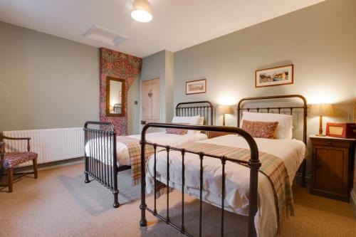 une chambre avec deux lits et une chaise dans l'établissement Pantile Cottage, à Pickering