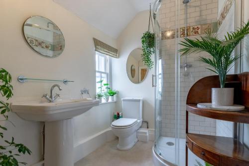 La salle de bains est pourvue de toilettes, d'un lavabo et d'un miroir. dans l'établissement Pantile Cottage, à Pickering