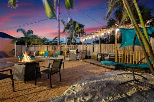 a patio with a table and chairs and a fire pit at Coastal Villa W Amazing Courtyard - Splash Pad! in Sarasota