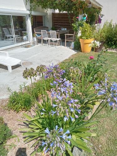 a garden with purple flowers in a yard at Grand studio tout équipé in Ploërmel