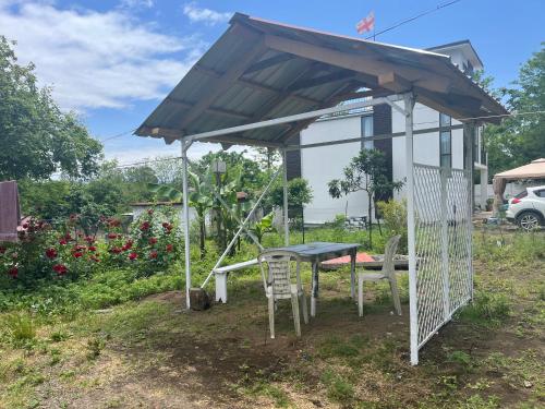 a shed with a table and chairs in a yard at OK Sahli in Shekvetili