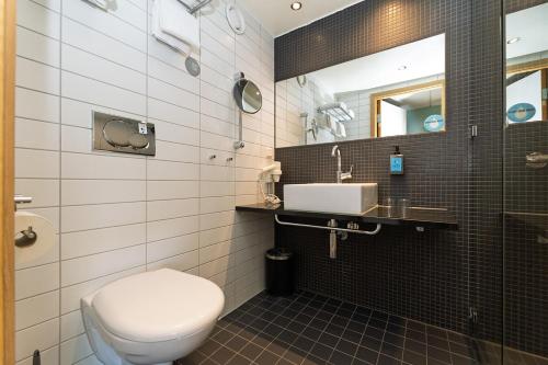 a bathroom with a toilet and a sink at Comfort Hotel RunWay in Gardermoen