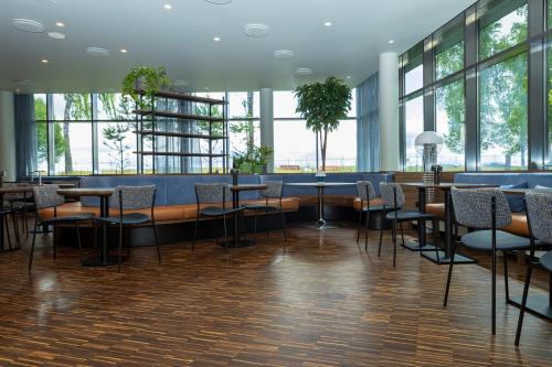 a restaurant with chairs and tables and windows at Comfort Hotel RunWay in Gardermoen