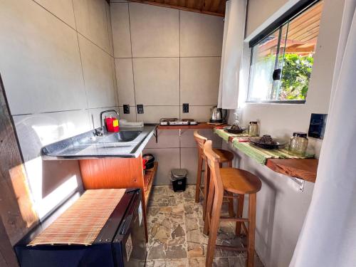 a small kitchen with a sink and a counter at Amorada do Rosa - 350m do Centrinho do Rosa in Praia do Rosa