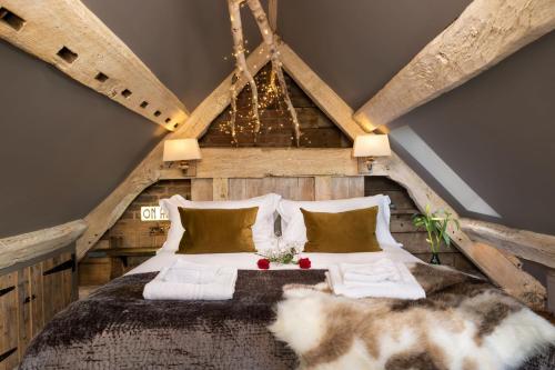 a bedroom with a large bed in an attic at Cheshire Boutique Bathhouse in Nantwich