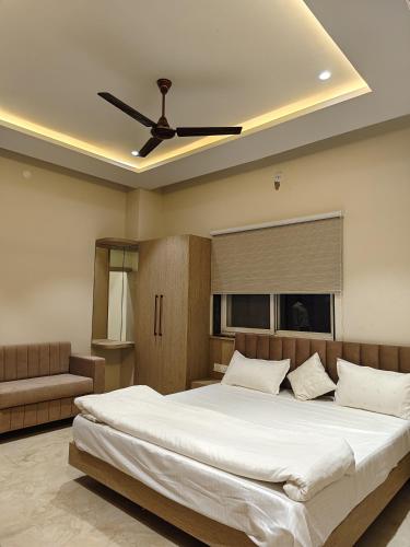a bedroom with a large bed with a ceiling fan at HOTEL HERITAGE Inn in Indore