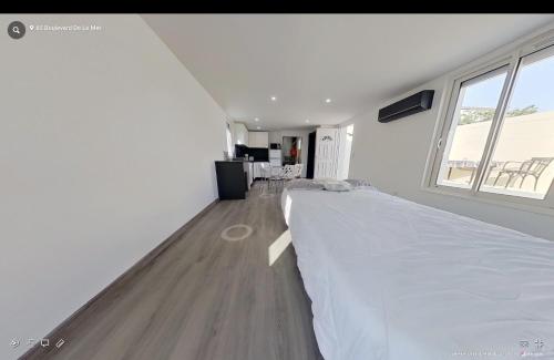 a white bedroom with a large bed and a window at Maison individuelle Aytré plage terrain clos 280m2 très calme in Aytré