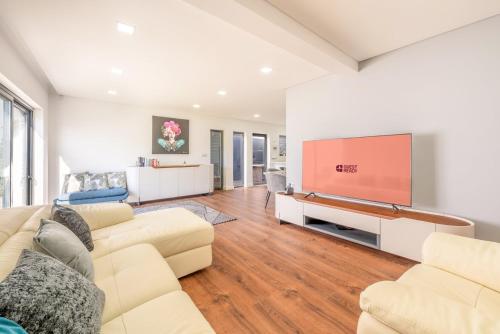 a living room with a couch and a tv at GuestReady - Villa Belas in Sintra