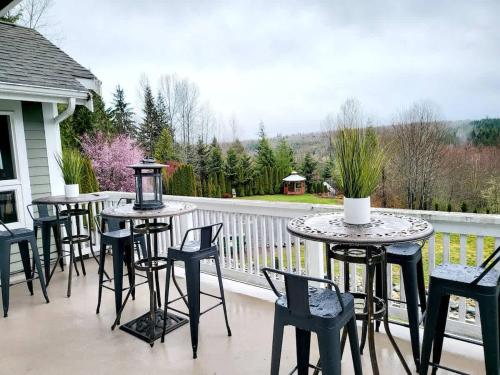 a group of tables and chairs on a balcony at Mountain View Estate Forest Hot Tub Full Arcade in Snohomish