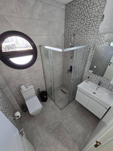 a bathroom with a shower and a toilet and a sink at Charming 1+1 Caesar Resort Apartment in Trikomo