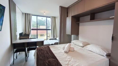 a hotel room with a bed and a desk and a table at Nawa Residence - Praia de Tamandaré in Tamandaré