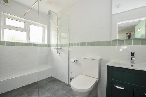 een badkamer met toilet en glazen douche bij 2 Porthilly Cottages in Wadebridge