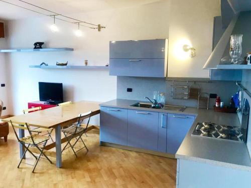 a kitchen with blue cabinets and a wooden table at Il Poggetto - Apartment Sea View in Residence with Pool in Rapallo