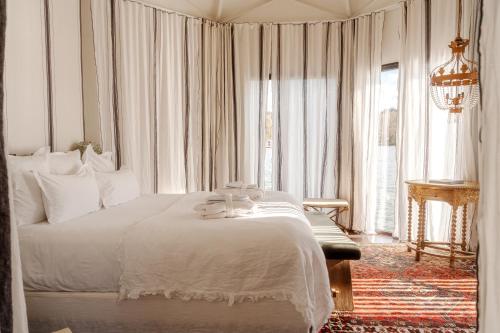 a bedroom with a white bed and a large window at Brindos, Lac & Château - Relais & Châteaux - Anglet Biarritz in Anglet