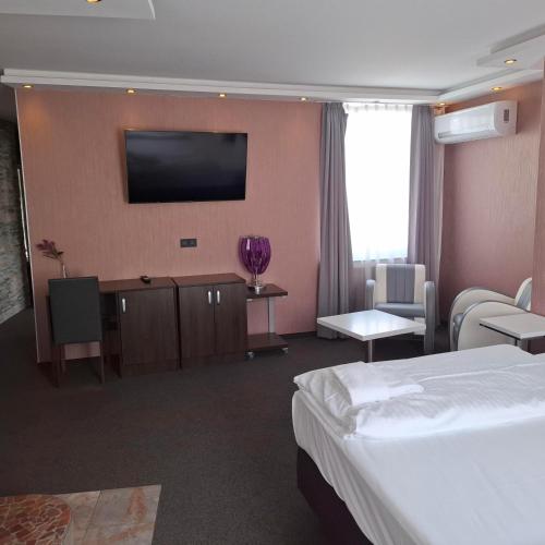 a hotel room with a bed and a flat screen tv at Stay-Inn Bielefeld Zentrum in Bielefeld