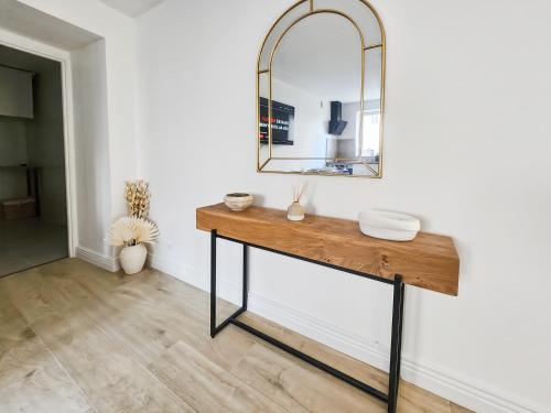 a dressing table with a mirror on a wall at Sleep & Cozy près de Disneyland et des commerces in Coupvray