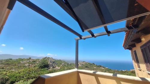 a view of the ocean from the balcony of a house at Casa Li Rosi Marini with a pool in Costa Paradiso
