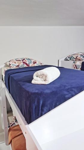 a white towel laying on top of a bed at Extração de Hotel com ótimo custo benefício in Curitiba