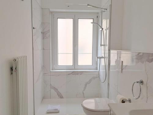 a bathroom with a shower and a toilet and a window at Urban Residence by Quokka 360 - Apartments with parking in Lugano in Aldesago
