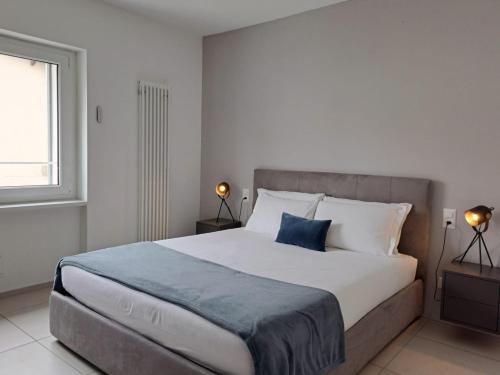 a bedroom with a large bed and two lamps at Urban Residence by Quokka 360 - Apartments with parking in Lugano in Aldesago
