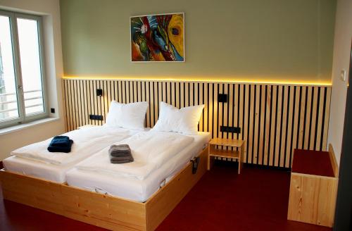 a bedroom with a large bed with white sheets at Anna und Sascha, Hotel und Café in Annaberg-Buchholz