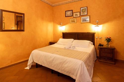 a bedroom with a bed with white sheets and a mirror at Bellavista Impruneta in Impruneta