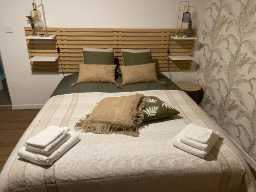 a bedroom with a bed with towels on it at House in forest proche GR and circuit in Saint-Mars-la-Brière