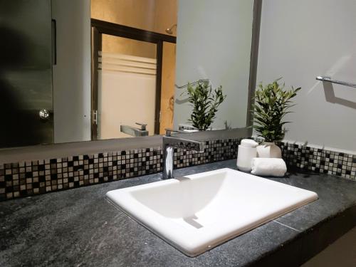 a bathroom with a white sink and a mirror at El Turix Bacalar in Bacalar