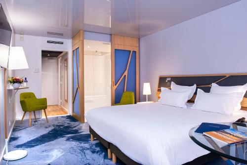 a hotel room with a large bed and a desk at Seeko'o Hotel Bordeaux in Bordeaux