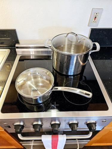 two pots and pans sitting on top of a stove at Polynesian Koi Pond Gardens Condo in Hilo w pool in Hilo