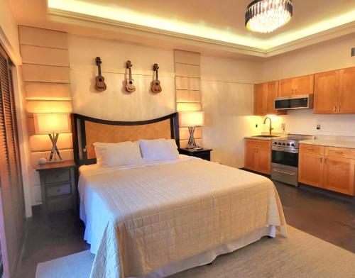 a bedroom with a bed with guitars on the wall at Polynesian Koi Pond Gardens Condo in Hilo w pool in Hilo
